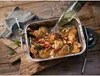 A roasting pan filled with chicken pieces, vegetables, and bacon is being seasoned with liquid from a bottle, set on a wooden table. Náhľad obrázku produktu