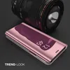 A rose gold flip case for a smartphone is shown in front of a camera lens. Produktbild-Vorschau