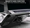 A black smartphone case with a kickstand is shown in a close-up shot, with a laptop and headphones in the background. Produktbild-Vorschau