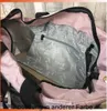 Close-up view inside a pink bag, showing a gray inner pocket with a zipper and repeating text pattern. Voir les images du produit