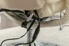 A close-up view of cables and connectors attached to the underside of a beige chair. Produktbild-Vorschau