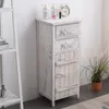 A white wooden cabinet with two drawers and a door, decorated with the words "Home" and "Love", stands next to a plant and a shelf. Náhľad obrázku produktu