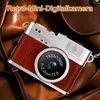 A retro-style digital camera with a brown leather-like finish is shown resting on a brown leather surface, possibly a bag or strap. Produktbild-Vorschau