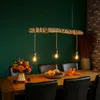 A dining table set for autumn with pumpkins, gourds, and flowers, illuminated by a rustic chandelier. Produktbild-Vorschau
