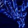A close-up shot of a tree trunk wrapped in blue LED string lights. Produktbild-Vorschau