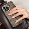 A hand holding a phone with a patterned case, resting on a brown bag. Podgląd zdjęcia produktu