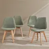 Four green chairs with wooden legs are arranged in a room with a textured wall. Anteprima dell’immagine prodotto