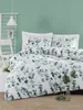 A bedroom scene with a bed dressed in green leaf-patterned bedding against a light green wall. Produktbild-Vorschau