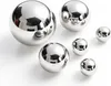 Several polished metal spheres of varying sizes are arranged on a white surface. Produktbild-Vorschau