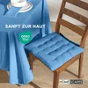 A blue tablecloth and a blue chair cushion are shown on a wooden floor. Náhled obrázku produktu
