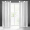 Two white sheer curtains hanging in front of a window with greenery visible outside. Produktbild-Vorschau