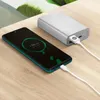 A smartphone is charging from a power bank on a wooden table. Podgląd zdjęcia produktu