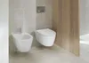 A modern bathroom with a wall-mounted toilet and bidet. Produktbild-Vorschau