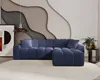 A modern living room with a blue sectional sofa against a textured wall. Náhled obrázku produktu