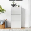 A white shoe cabinet with three flip-down doors is shown in a room with a plant and a basket. Anteprima dell’immagine prodotto
