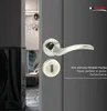A close-up of a door handle and lock mechanism on a gray door, with a glimpse of an interior hallway in the background. Produktbild-Vorschau