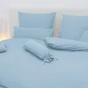 A neatly made bed with light blue bedding and pillows. Produktbild-Vorschau