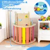A wooden indoor climbing structure for children, with colorful bars and attached toys, placed in a room next to a white cabinet filled with toys. Voir les images du produit