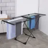 A black metal drying rack with several towels hanging on it, placed in a bathroom setting. Produktbild-Vorschau