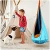 A young girl and her dog are playing in a room with a teepee and a hanging cocoon swing. Voir les images du produit