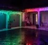 A courtyard at night, decorated with colorful LED string lights. Náhled obrázku produktu