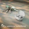 A pair of white wireless earbuds in their charging case, placed next to a set of keys on a textured surface. Produktbild-Vorschau