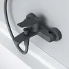 A close-up view of a black bathroom faucet mounted on a white wall. Produktbild-Vorschau