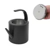 A black kettle and its silver lid are shown against a white background. A hand is holding the lid. Podgląd zdjęcia produktu