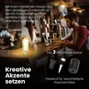 A man is working on a laptop at a bar counter, with a bottle lamp and beer glasses on the counter. Several bottle stoppers are displayed in the foreground. Anteprima dell’immagine prodotto