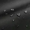 A close-up of a black fabric surface with water droplets on it. Produktbild-Vorschau