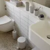 A modern bathroom with a toilet, sink, and various bathroom accessories. Produktbild-Vorschau