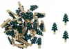 A pile of small wooden clothespins decorated with green Christmas trees with white dots, on a white background. Produktbild-Vorschau