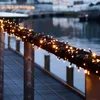 String lights wrapped around a railing overlooking water. Produktbild-Vorschau
