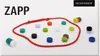 A collection of colorful magnetic pieces arranged on a white surface, with a red cord forming a loop around some of them. The product name 'ZAPP' is displayed prominently in the top left corner. Voir les images du produit
