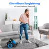 A woman is vacuuming a rug in a living room with a sofa and armchair. Produktbild-Vorschau