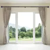 A sliding glass door with curtains and a curtain rod, overlooking a garden and mountains. Produktbild-Vorschau