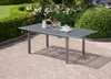 A garden table and chairs set on a patio with lush greenery in the background. Produktbild-Vorschau