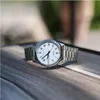 A silver Casio watch with a white face is placed on a wooden surface. Produktbild-Vorschau