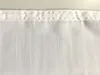 A close-up view of the top hem of a white curtain. Produktbild-Vorschau