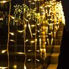 A string of warm white icicle lights draped over a railing and stairs at night. Anteprima dell’immagine prodotto
