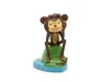 A toy monkey figurine sitting on a green rock with a blue base. Produktbild-Vorschau