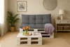 A living room scene with a pallet sofa and coffee table, decorated for spring. Produktbild-Vorschau