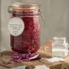A large Kilner jar filled with pickled red cabbage sits on a wooden board next to a small jar of salt and some loose red cabbage leaves. Anteprima dell’immagine prodotto
