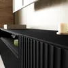 A close-up view of a black TV cabinet with a modern, ribbed front design. Produktbild-Vorschau