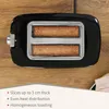 A black toaster with two slices of toast inside, set against a wooden background with a white overlay at the bottom containing text. Podgląd zdjęcia produktu