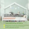 A white house-shaped bed frame with built-in shelving and storage compartments, set against a light green wall. Produktbild-Vorschau