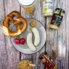 A traditional German meal with sausages, pretzel, radishes, mustard, and beer. Produktbild-Vorschau