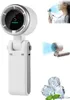 A collage showcasing a portable fan, its use by a person, and ice cubes. The main image displays the fan from the front with a digital speed indicator. A smaller image shows the fan being held by a person near their face, with blue air currents indicating  Náhľad obrázku produktu