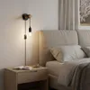 A bedside table next to a bed with a wall lamp above it. Produktbild-Vorschau