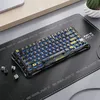 A gaming keyboard is placed on a desk mat next to a laptop. Produktbild-Vorschau
